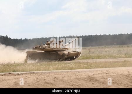 A U.S. Army M1A1 Abrams tank traverses a range at Bemowo Piskie Training Area, Poland June 13 as Soldiers with Bravo Company, 1st Battalion, 9th Cavalry Regiment, 2nd Armored Brigade Combat Team, 1st Cavalry Division supporting the 4th Infantry Division, prepare to conduct a live-fire exercise. The 4th Infantry Division's mission in Europe is to engage in multinational training and exercises across the continent, working alongside NATO allies and regional security partners to provide combat-credible forces to V Corps, America’s forward deployed corps in Europe.  (U.S. Army photo by Capt. Danie Stock Photo
