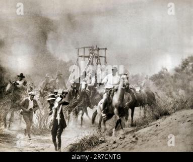 Hollywood, California:   1923 Western star Harry Carey and the accompanying film crew escaping flames from a scripted forest fire that got out of control and burned several of the members of the company along with much equipment and props. Stock Photo