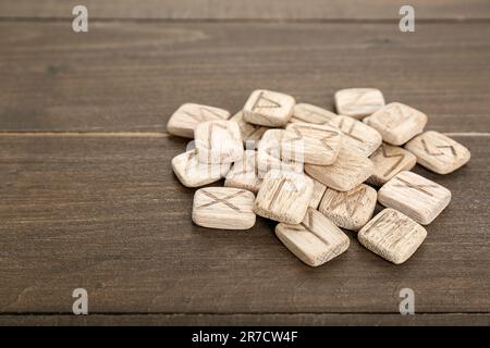 Pile of runes with different symbols on wooden table Stock Photo