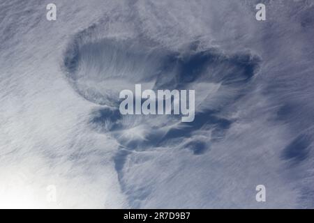 Cirrus clouds are short, detached, wispy-like clouds made of ice crystals found at high altitudes. Stock Photo