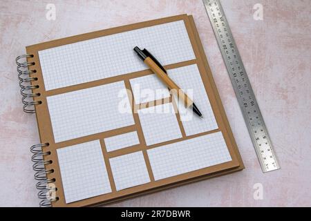 Square lined paper cut outs on ring bound scrapbook. Metal ruler bamboo pen. Copy space Stock Photo
