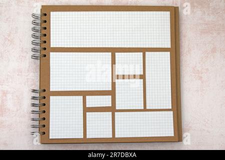 Square lined paper cut outs on ring bound scrap book. Different sizes. Copy space Stock Photo