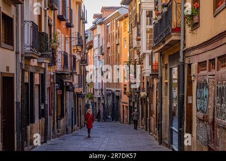 Vitoria-Gasteiz, Spain - 26 March 2023: People walking in a colorful street with flowers on balconies  Stock Photo