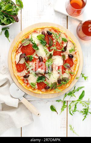 Pizza. Margherita pizza with mozzarella, tomato, olives and fresh greens. Top view Stock Photo