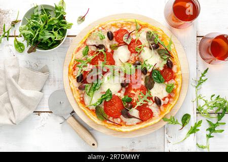 Pizza. Margherita pizza with mozzarella, tomato, olives and fresh greens. Top view Stock Photo