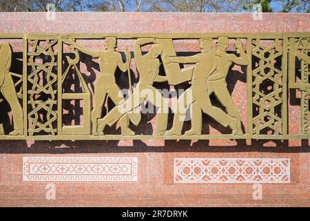 A panel depicting construction workers. At the Monument of Courage, a Soviet era memorial to the victims of the earthquake of 1966. In Tashkent, Uzbek Stock Photo