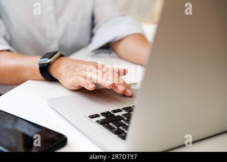 Close up photo of females fingers on the touchpad of laptop, woman business person using her laptop in the office. Stock Photo