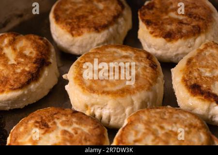 Close-up of cottage cheese cheesecakes fried in a frying pan. The process of cooking delicious homemade food. Stock Photo