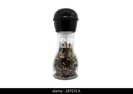 Pepper grinder. A Professional pepper mill of colored peppers mix isolated on a white background. Front view of glass pepper mill isolated on white. Stock Photo