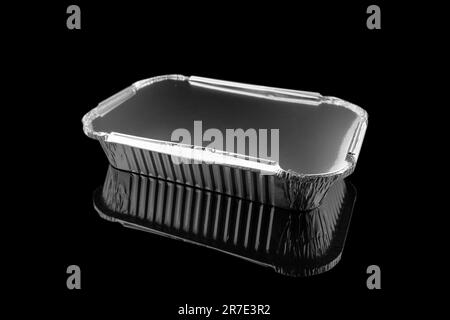 Foil baking dish closeup isolated on a black background. Empty disposable square aluminium foil baking dish isolated on black Stock Photo