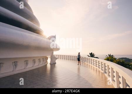 Tourist admiring large Peace Pagoda against ocean near Galle in Sri Lanka. Stock Photo