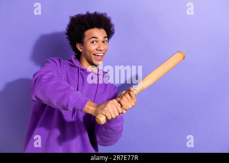 Photo of excited positive person have good mood hands hold baseball bat hit ball isolated on violet color background Stock Photo
