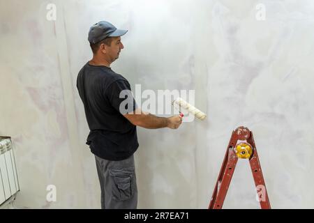 Male builder, master office, plasterer with a tool in working clothes Stock Photo