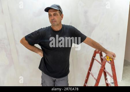 Male builder, master office, plasterer with a tool in working clothes Stock Photo