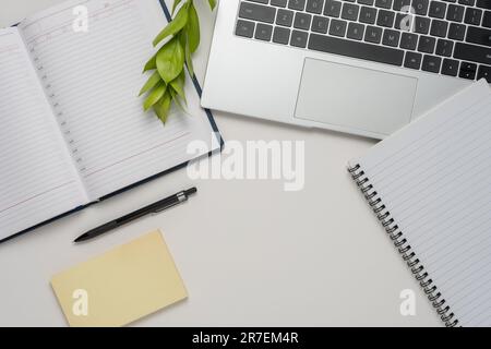 Modern white office desk table with laptop, notebook and other supplies. Top view, flat lay. Stock Photo