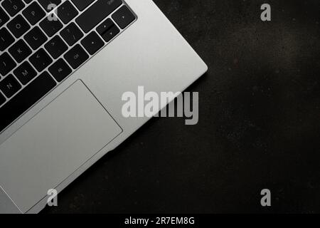 Top view of laptop on black background. Flat lay, top view office table desk. Stock Photo