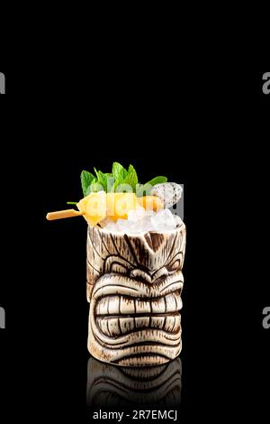 Fresh Zombie Tiki cocktail with ice in ceramic cup. Fruity frozen alcoholic cocktail. Stock Photo