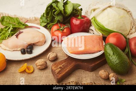 Menu for low carb, FODMAP diet with vegetables, fruits, chicken fillet, smoked salmon, greens, nuts, olives. Healthy lifestyle. Stock Photo