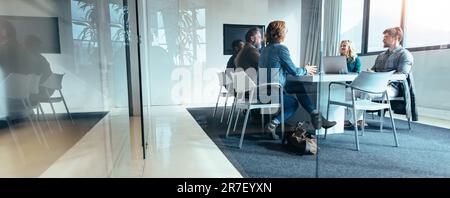 Group of business people sitting in a conference room, discussing and brainstorming over a new project. Creative team of professionals is collaboratin Stock Photo