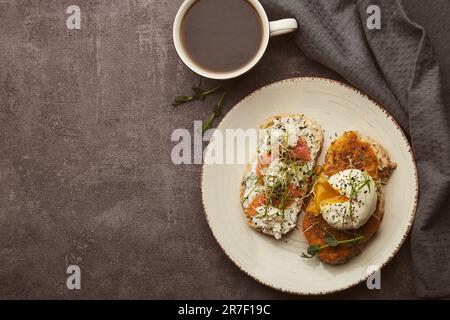 Healthy food sandwiches with Greek yogurt and zucchini spread, poached egg, salmon and coffee. Copy space Stock Photo