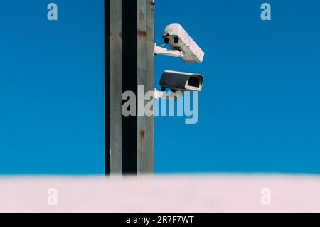 IP CCTV camera or surveillance camera for security on a poll with blue sky and cloud background. Stock Photo