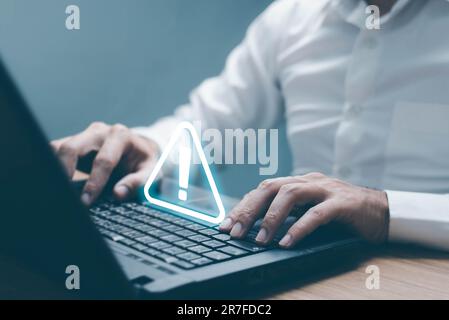 Businessman using computer laptop with triangle caution warning sing for notification error and maintenance concept. Stock Photo