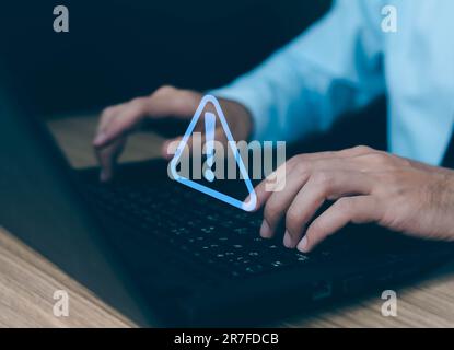 Businessman using computer laptop with triangle caution warning sing for notification error and maintenance concept. Stock Photo