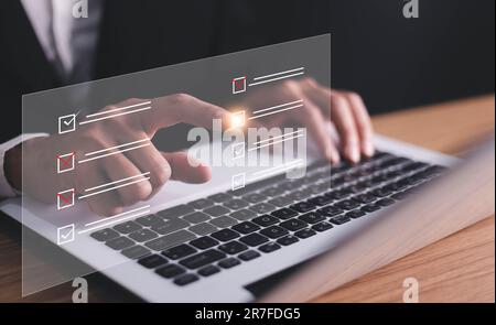 Document management system DMS. Assessment form, questionnaire, checklist and clipboard task management. Businessman working on laptop computer produc Stock Photo