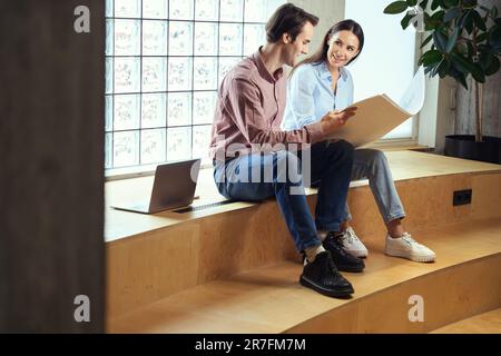 Female architect and her colleague analyzing floor plans together Stock Photo