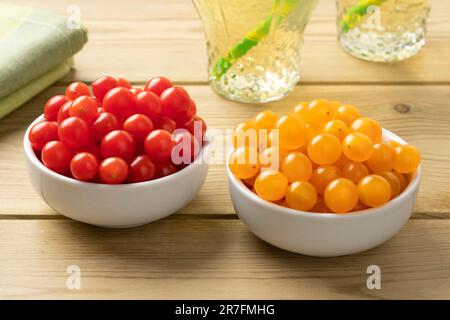 White bowls with fresh red and yellow Tomberry tomatoes close up Stock Photo