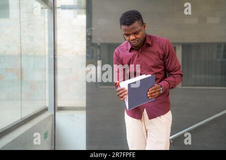 young black businessman looking at folder outside of the office Stock Photo