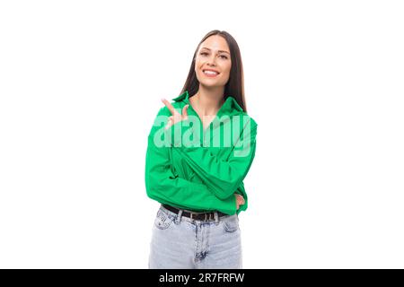brown-eyed brunette young business lady in a green shirt shows her hand to the side on a white background with copy space Stock Photo