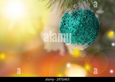 Abstract Christmas background.Glitter Christmas ball on blurred background.Christmas tree toy in the snow. Stock Photo