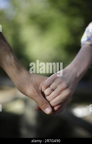 A loving couple standing together, holding hands in a loving embrace Stock Photo