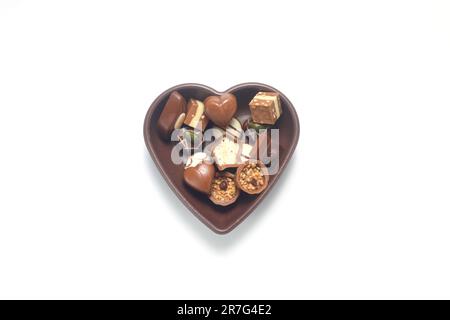 Colorful Chocolates in a heart-shaped bowl. On a white background. Stock Photo