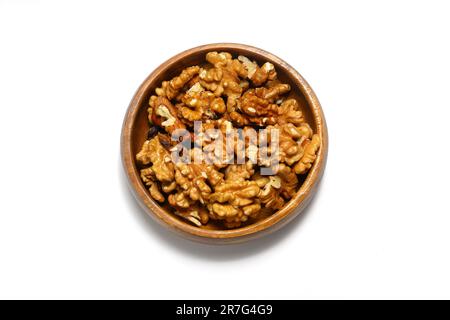 Peeled walnuts in wooden bowl isolated on white background. Top view. Stock Photo