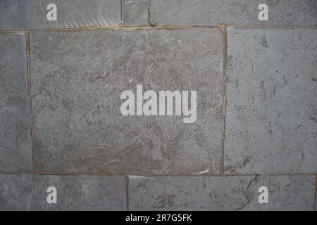 Image for urban backgrounds of a dark gray rectangular tesserae floor with marked joints between bricks and wear due to time and use Stock Photo