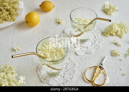 Black elder flowers in glasses of lemonade with golden metal straws. Zero waste concept. Stock Photo