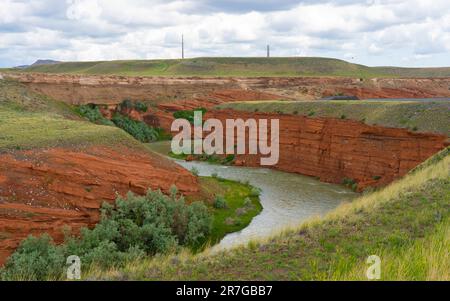 Red sandstone chug water rock forms cliffs in s-curve around Shoshone River in Cody, Wyoming. River flows from Yellowstone Park on a cloudy day. Stock Photo
