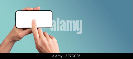 Hand holding smartphone, clicking on blank screen mock-up, tapping on mobile phone display. Banner background with copy space for text. Stock Photo