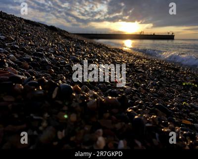 Looking Across a Decorative Stack of Different Coloured Stones, Pebbles and Cobbles at Hampton Stone Beach, Hampton Pier in the Distance. Stock Photo