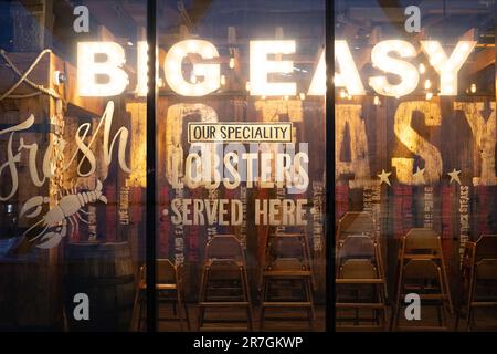 London, UK - January 17 2020:  A sign on the window of the Big Easy restaurant advertises 'Fresh Lobsters Served Here'. Taken at night with name lit. Stock Photo