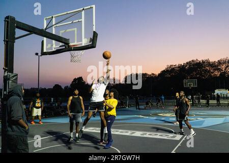 UK weather, Clapham, London, 15 June 2023: On a light summer evening after a hot day, basketball players make use of floodlit courts on Clapham Common to get some practice in. Credit: Anna Watson/Alamy Live News Stock Photo