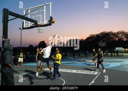 UK weather, Clapham, London, 15 June 2023: On a light summer evening after a hot day, basketball players make use of floodlit courts on Clapham Common to get some practice in. Credit: Anna Watson/Alamy Live News Stock Photo