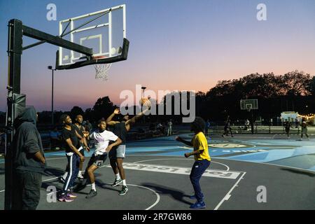 UK weather, Clapham, London, 15 June 2023: On a light summer evening after a hot day, basketball players make use of floodlit courts on Clapham Common to get some practice in. Credit: Anna Watson/Alamy Live News Stock Photo