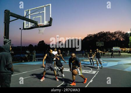 UK weather, Clapham, London, 15 June 2023: On a light summer evening after a hot day, basketball players make use of floodlit courts on Clapham Common to get some practice in. Credit: Anna Watson/Alamy Live News Stock Photo