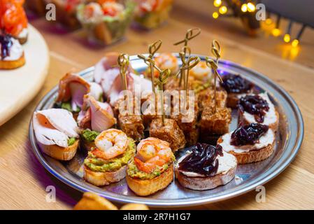 healthy appetizing plate of bruschettas for brunch with few tuna canapes on skewers with tuna shavings Stock Photo