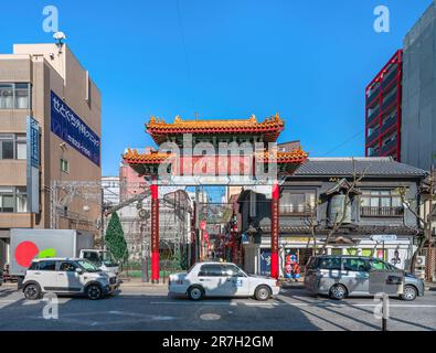 nagasaki, kyushu - dec 12 2022: Car traffic in front the landmark of Nagasaki Shinchi Chinatown, the South Gate showcasing the unique cultural fusion Stock Photo