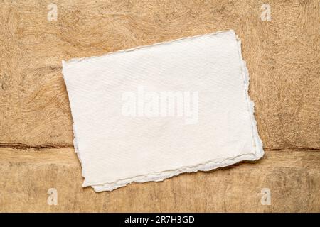 sheet of blank white Khadi rag paper against abstract landscape in