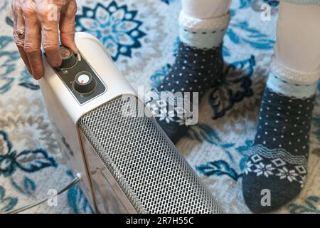 Electric Space Heater, Elderly Woman Wearing Thick Socks Stock Photo